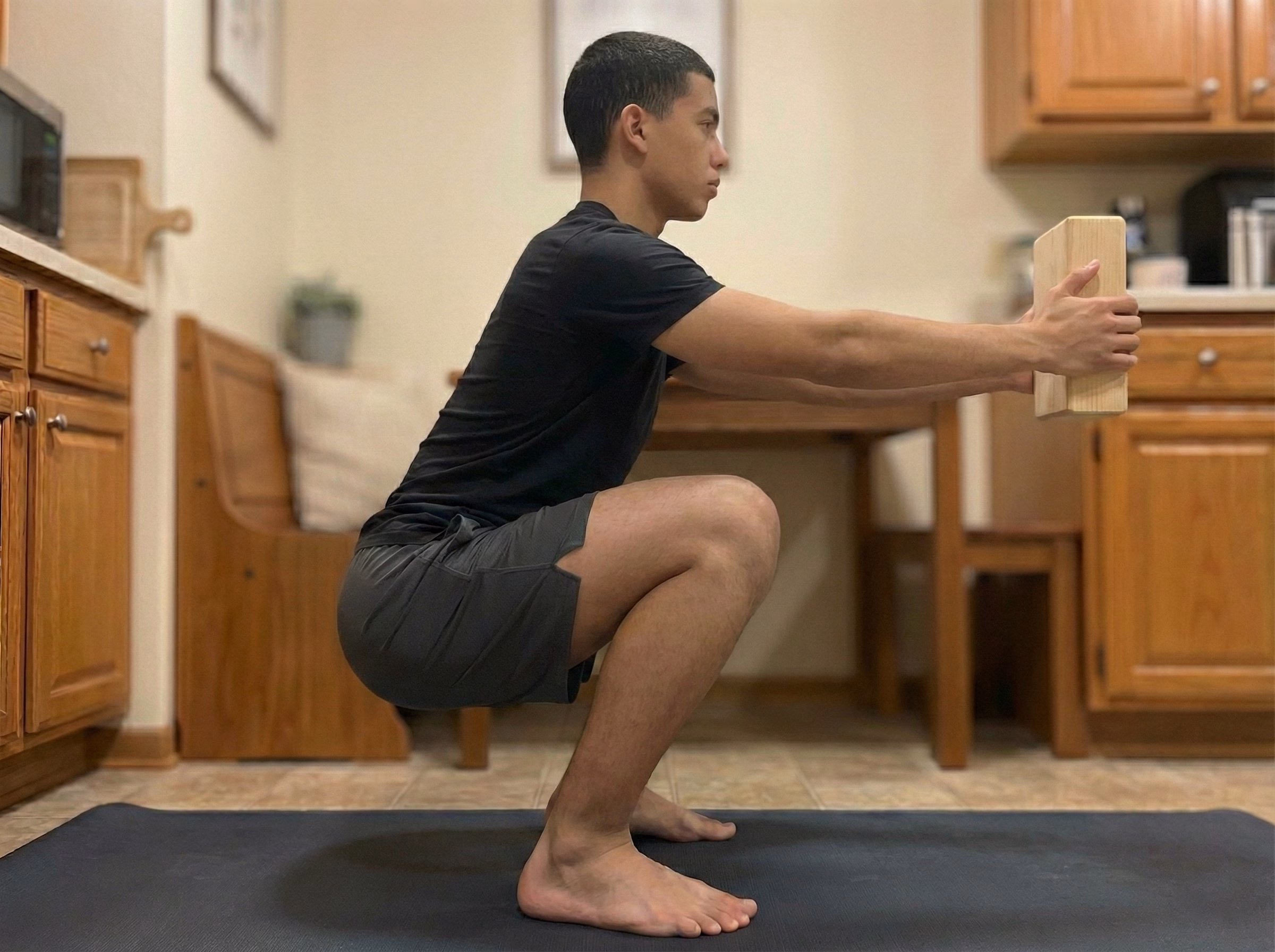 Counterbalanced deep squat hold holding a weight in front