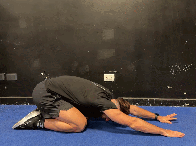 Person demonstrating the Child's Pose arm walk variation