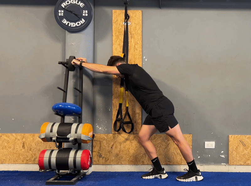 Person demonstrating a wall calf stretch