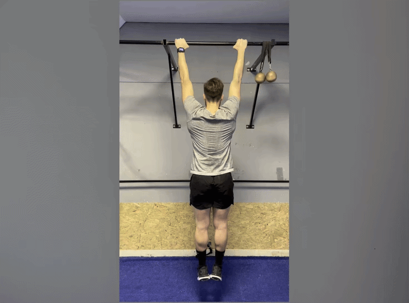 Person demonstrating the passive hang for spinal decompression